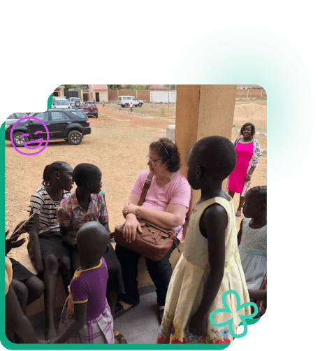 The president of SMRO Claire Saad engaging with a group of children in Sudan outdoors.